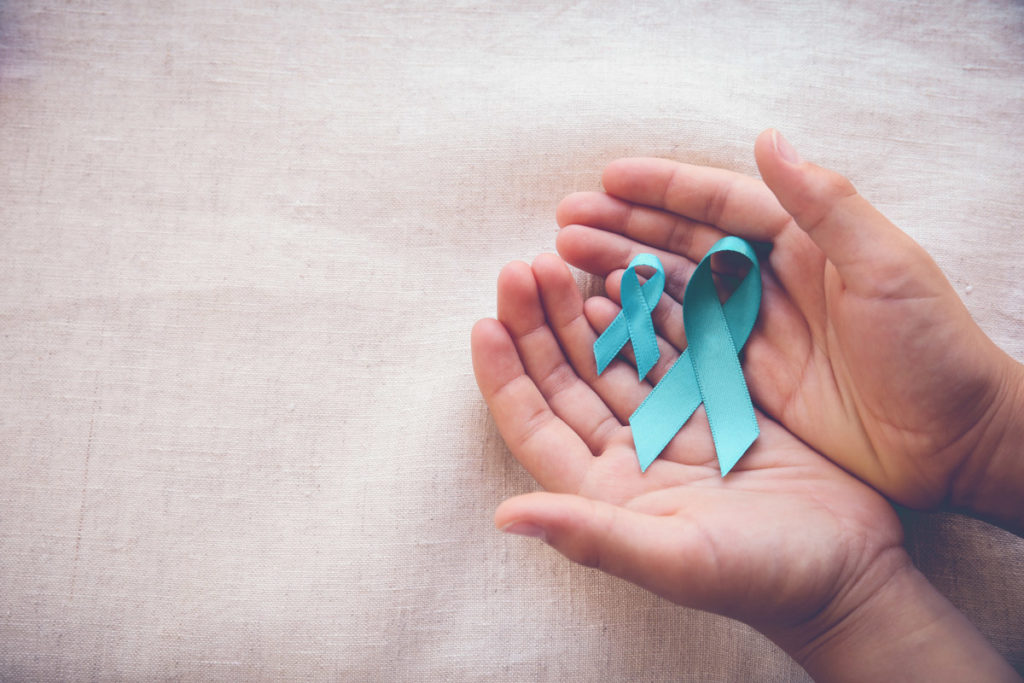 cupped hands hold two teal ribbons for Sexual Assault Awareness Month